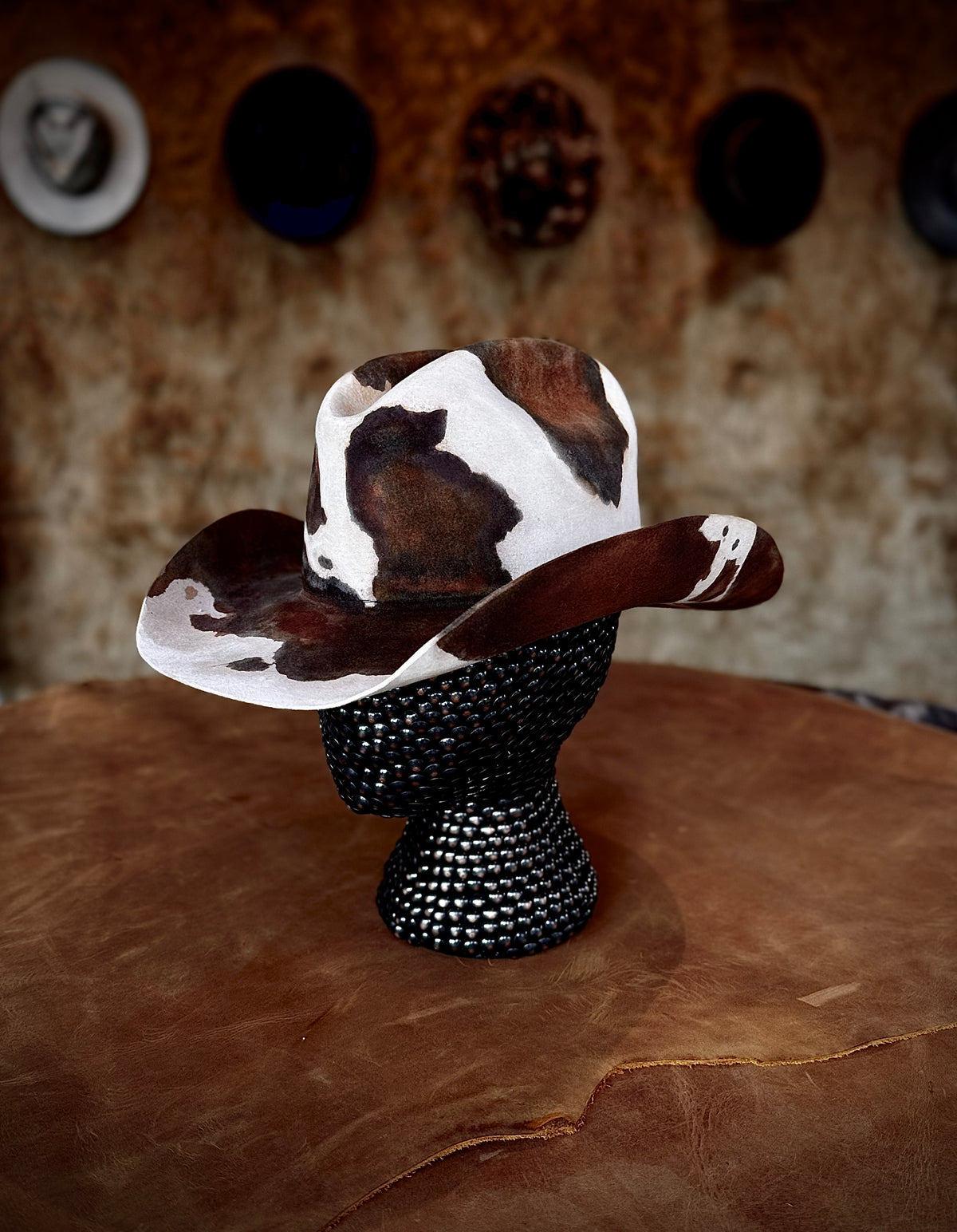 CowHide Crown limited-edition cowhide hat shown from a second angle on a black textured mannequin