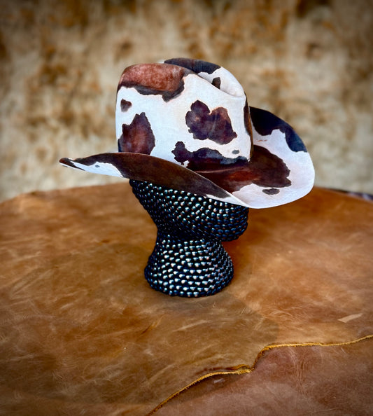 CowHide Crown limited-edition cowhide hat displayed on a black textured mannequin over a leather surface