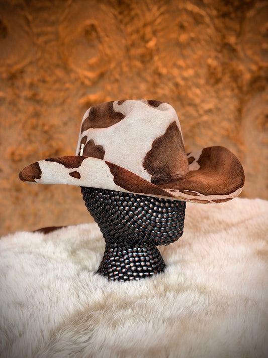 CowHide Crown cow print cowboy hat in profile on a stand — TROVADOR